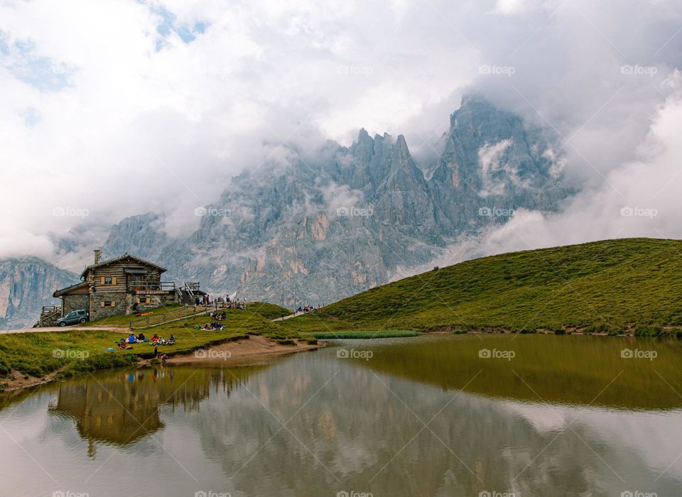 loh cabin reflected in pond backed by mountains