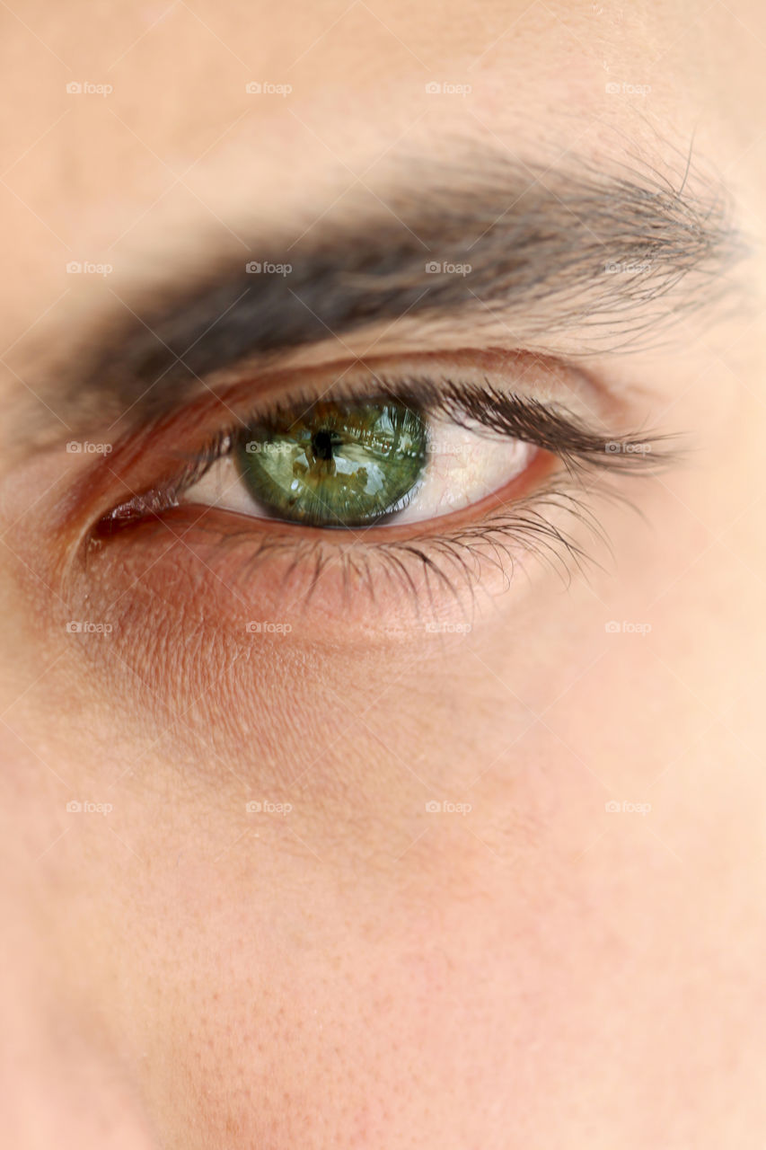 Closeup green eye of a young man