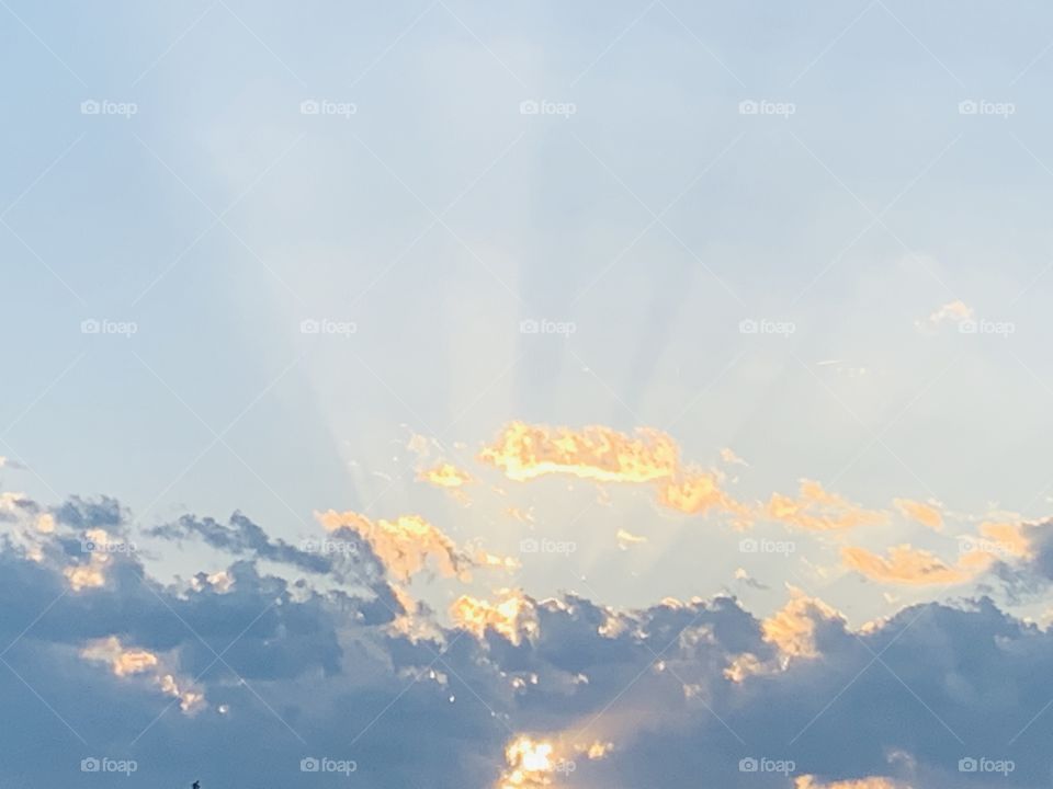 Beautiful blue and gold sky with visible rays of the sun in late summer