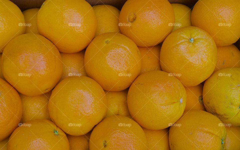 A pile of arranged oranges for sale at an outside market