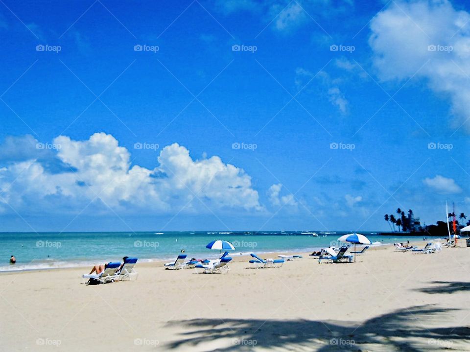 A scenic view on the beach as sun bathers soak up the sun. 