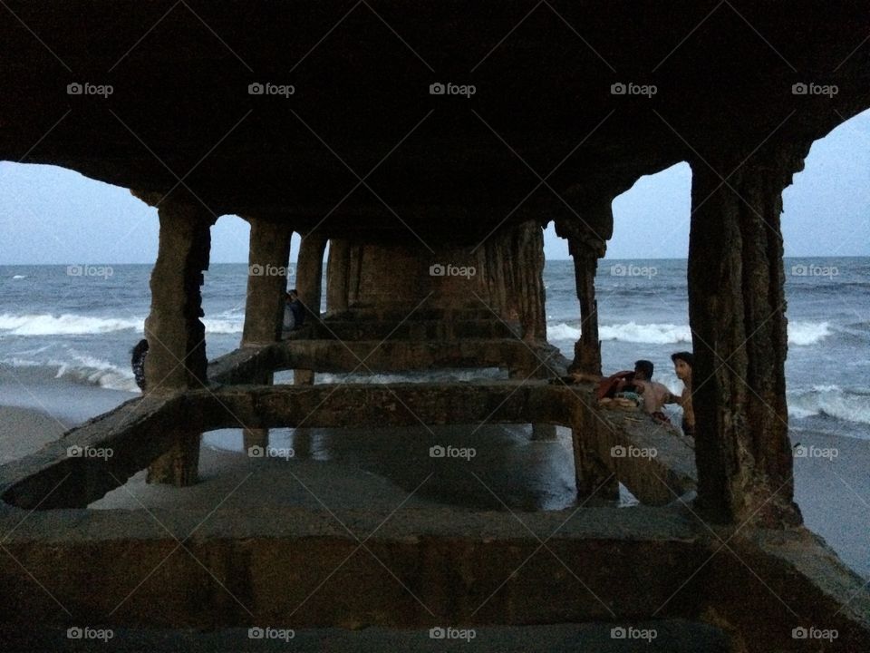 View from under an old bridge by the sea. 