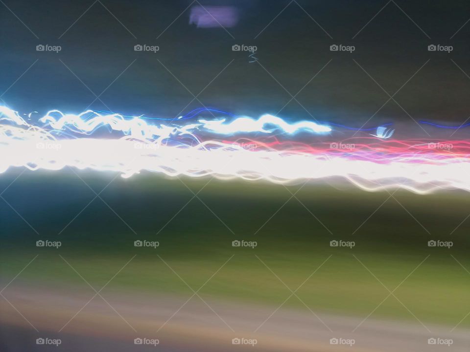 Light painting created through various light sources residents
vehicles headlight to brake light street lamp police light. Long exposure in night traffic on road. Blurred lights captured while driving at
night