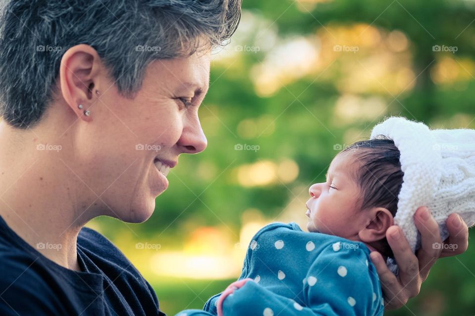 Mother smiles at newborn daughter, mother and daughter tender moments, showing love between mother and daughter, baby and mother spend precious moments together 