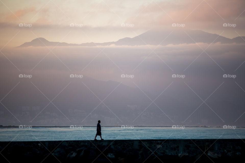 A man walking by beautiful mountains in the morning