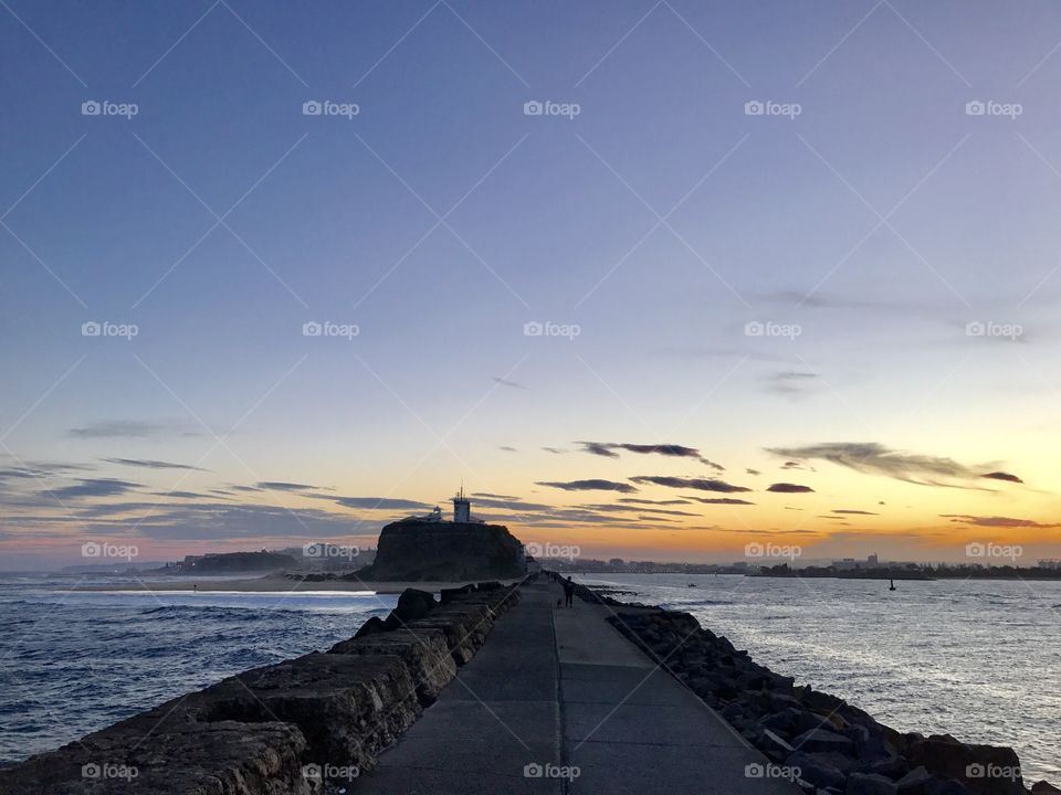 Sunset behind the break wall and lighthouse, Newcastle NSW Australia 