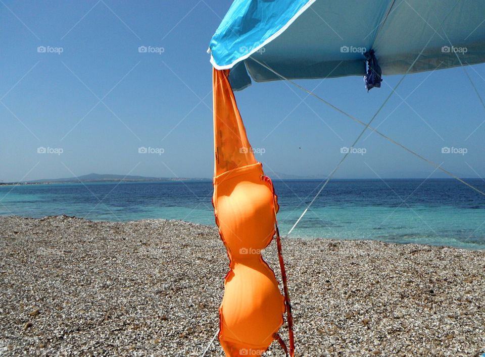 orange color story: orange bikini drying in front of sea