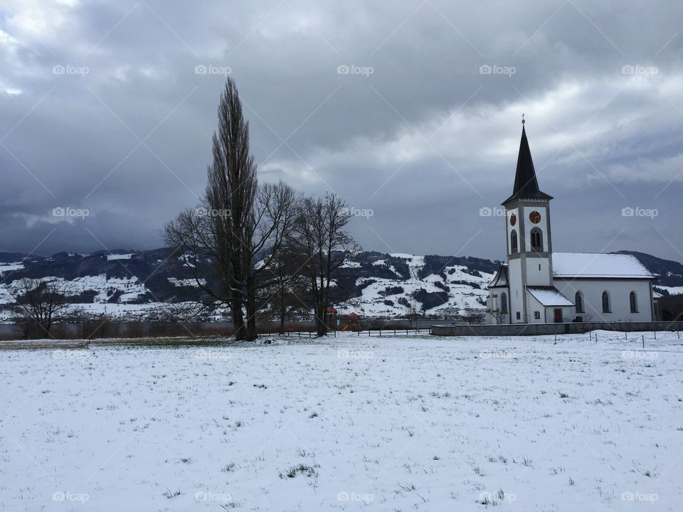 First snow this winter in Switzerland - very cold and so much fun to do a walk along the lake with view to the other lake side and a small church.