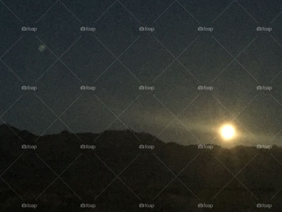 Full moon setting over the southern desert mountains. 