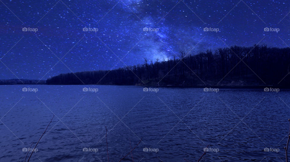 Starry sky over lake at night