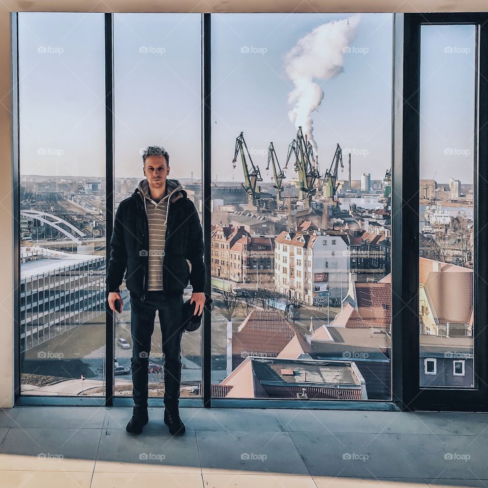 Man standing near glass window