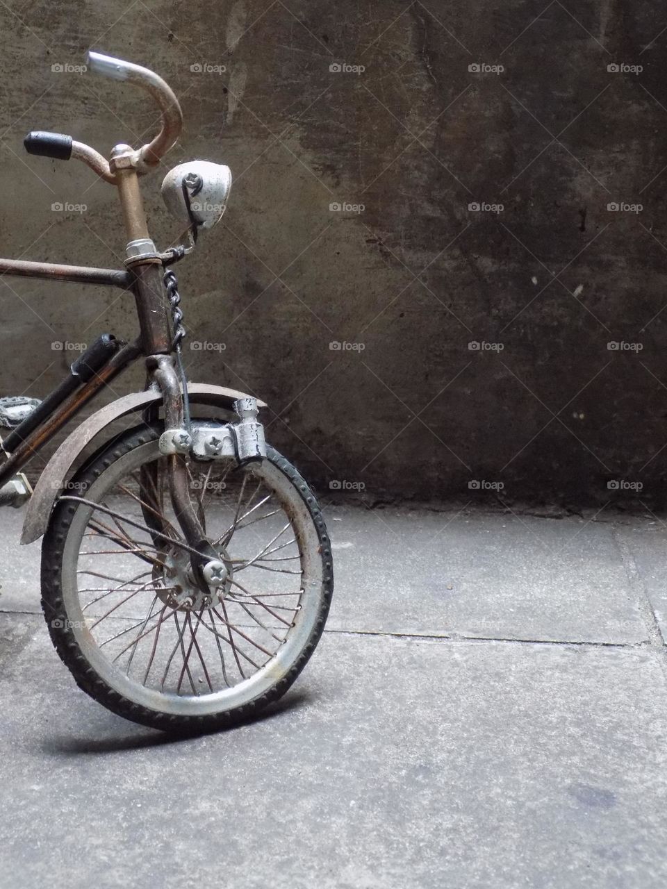 Old, rusty and broken toy bicycle