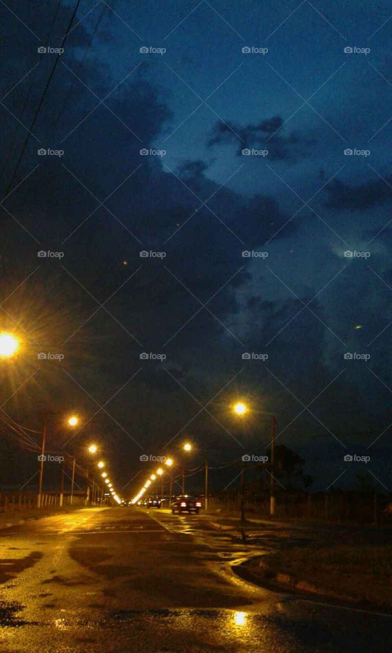 Rua iluminada, noite.
