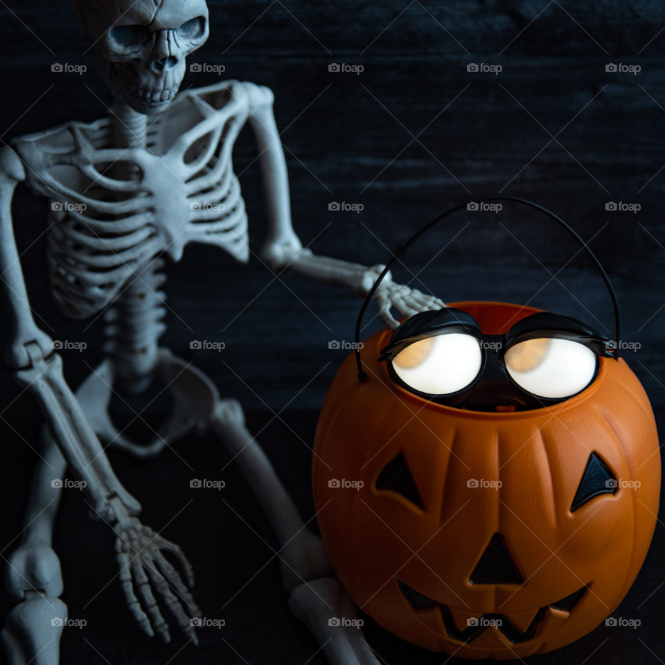 1:1 image of glowing eye Halloween decorations next to a skeleton 
