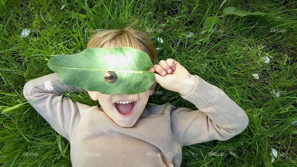 child with a leaf on his face