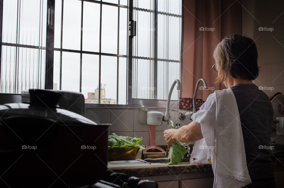 a woman sanitizing vegetables to make a delicious salad. A daily habit to take care of health.