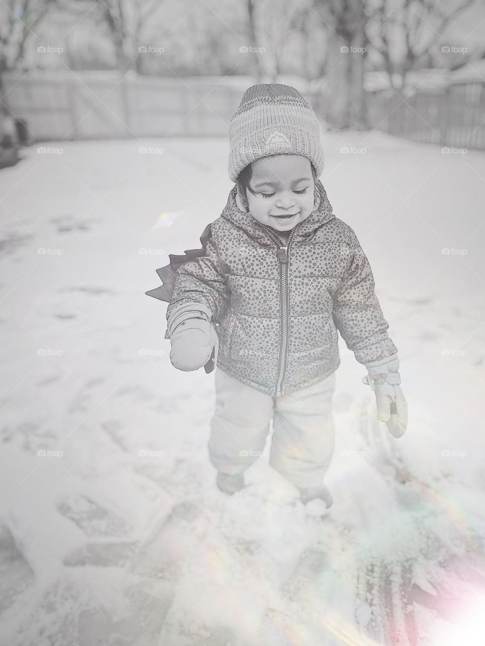 Toddler girl plays in the snow for the first time, portrait of a toddler in the snow, toddler enjoys the winter weather outside, toddler girl plays outside, baby it’s cold outside, snowy toddler girl, smartphone photography 