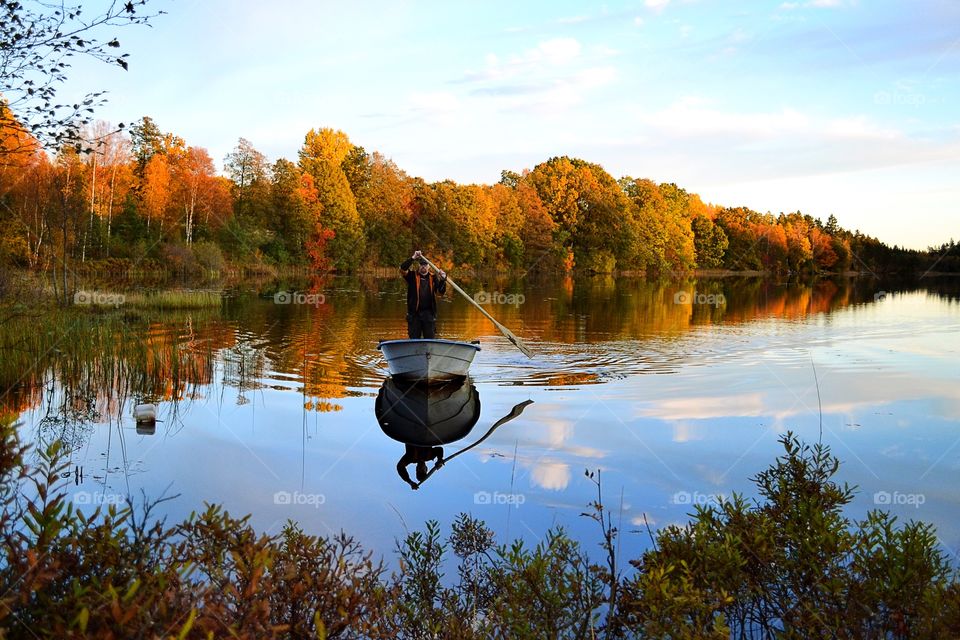 Man boating in the lake during autumn
