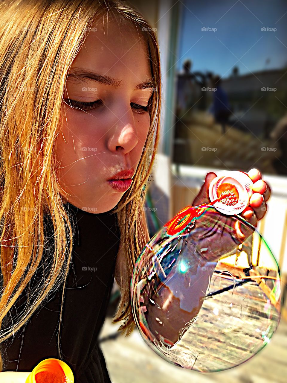 Close-up of a cute girl blowing bubbles