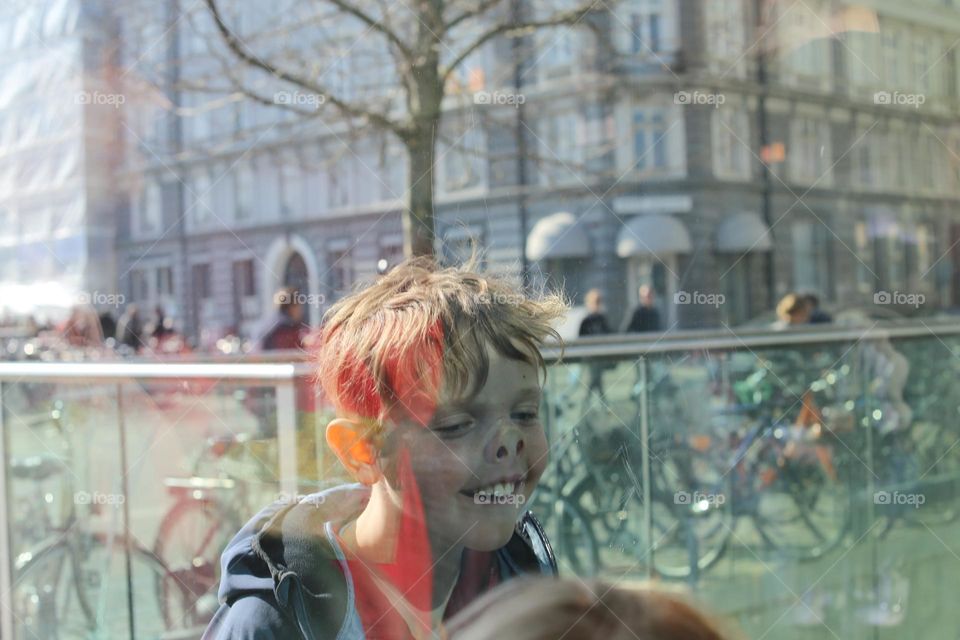 Boy in window making funny faces 