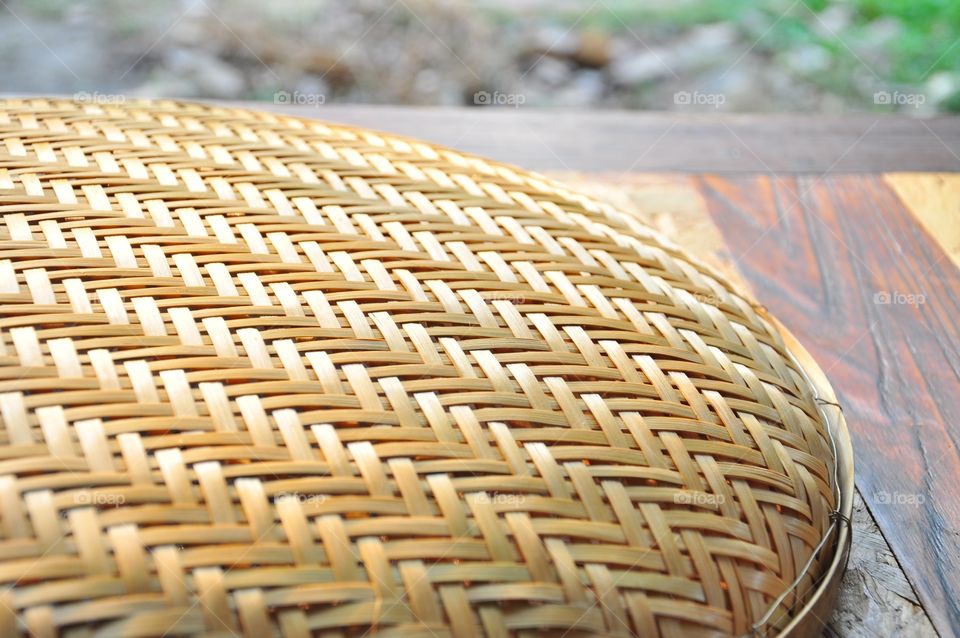 Brown woven bamboo closeup texture. Wicker texture. Winnowing or threshing basket on the table. Woven bamboo pattern. Diagonal pattern texture. Abstract texture.