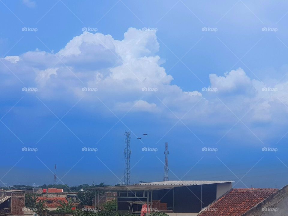 The view in the afternoon, the sky is quite cloudy, the sky looks like a blue, the clouds are bright white, and the air feels warm