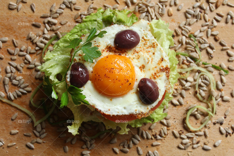 Tasty burger with fried egg, olives, lettuce, seeds 1