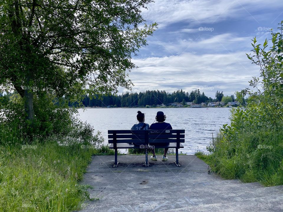 Romantic couple seating on the bench near river. Lovers