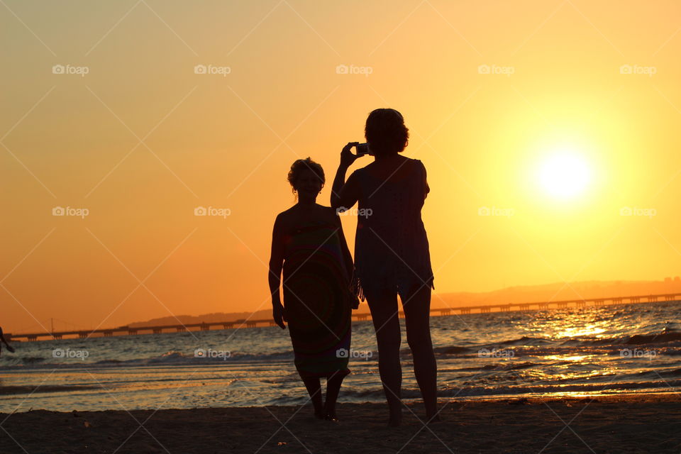 Daughter photographing her Mother during Sunset 