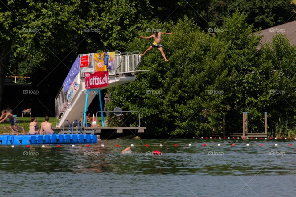 Teenage Boy Jumping Off A Springboard