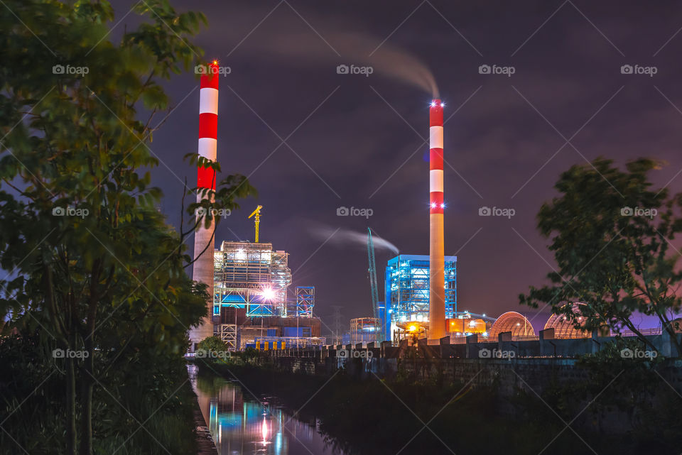 This is electric steam power plant located in Cilacap district, Central Java, Indonesia, captured in night time with wonderful lights coming from the building