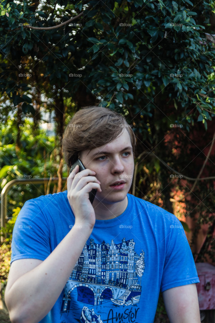 A portrait of the handsome teenager talking on the phone