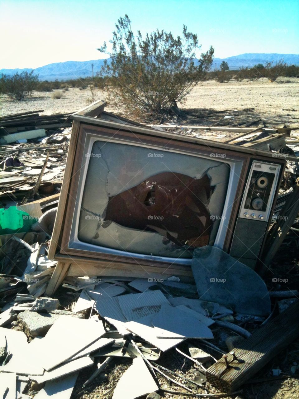 Smashed TV. An old smashed TV sits in the desert.