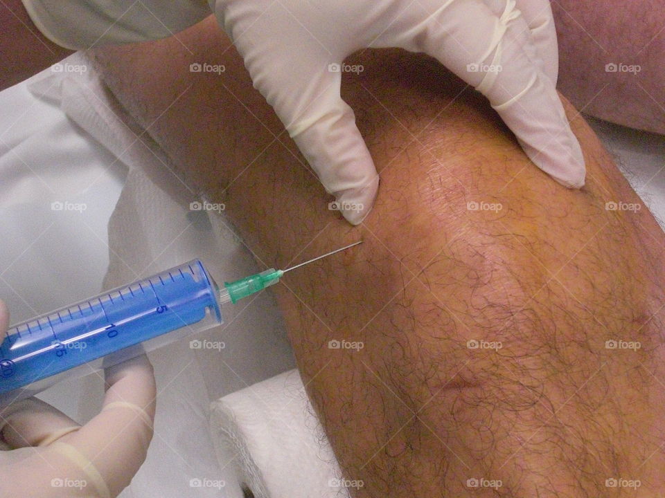 Doctor injecting Knee Joint