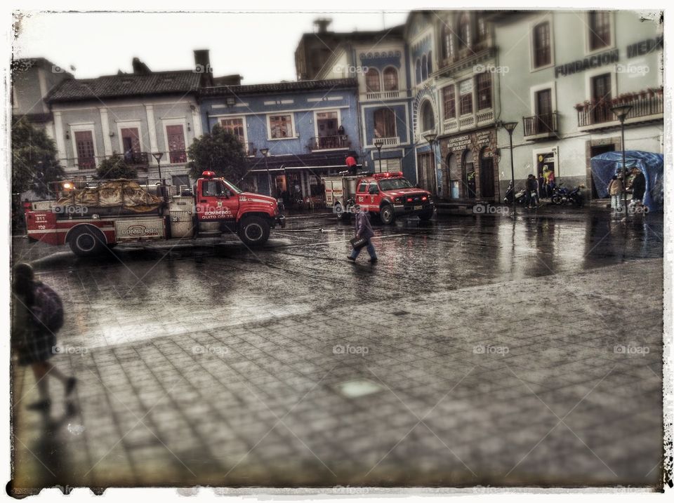 Firemen of a rainy day. Old school firemen arrived to a building placed next to the square, on a rainy day, in Quito.