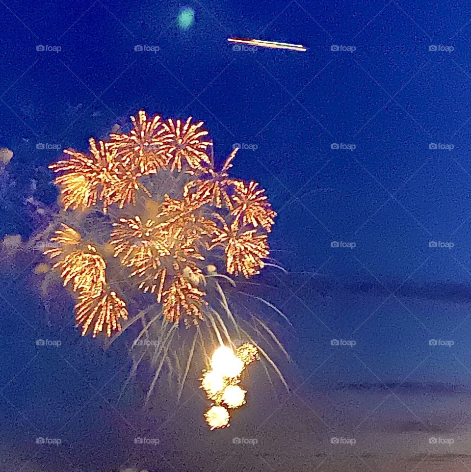 Firework cluster with airplane overhead 