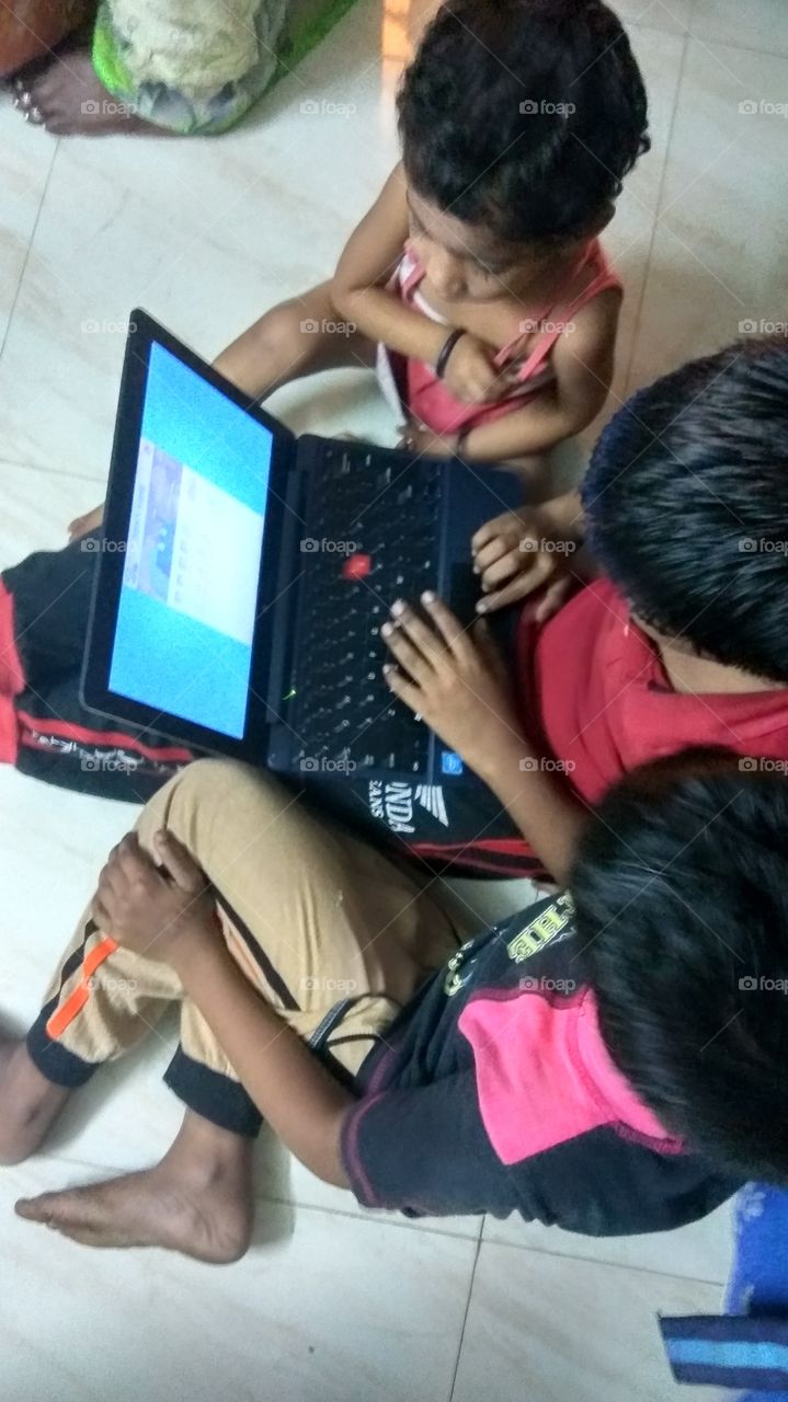 child operating laptop playing games