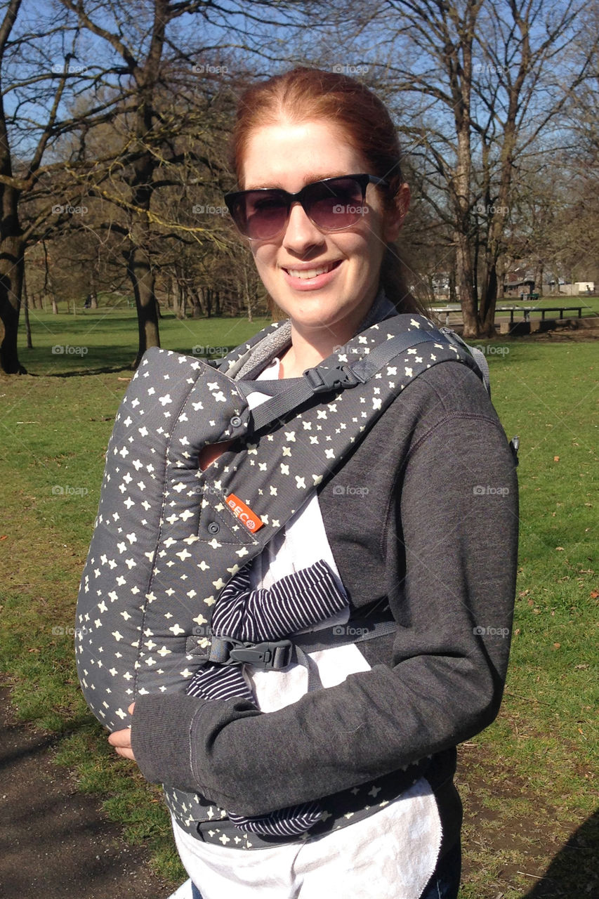 Portrait of smiling mother with baby in sling