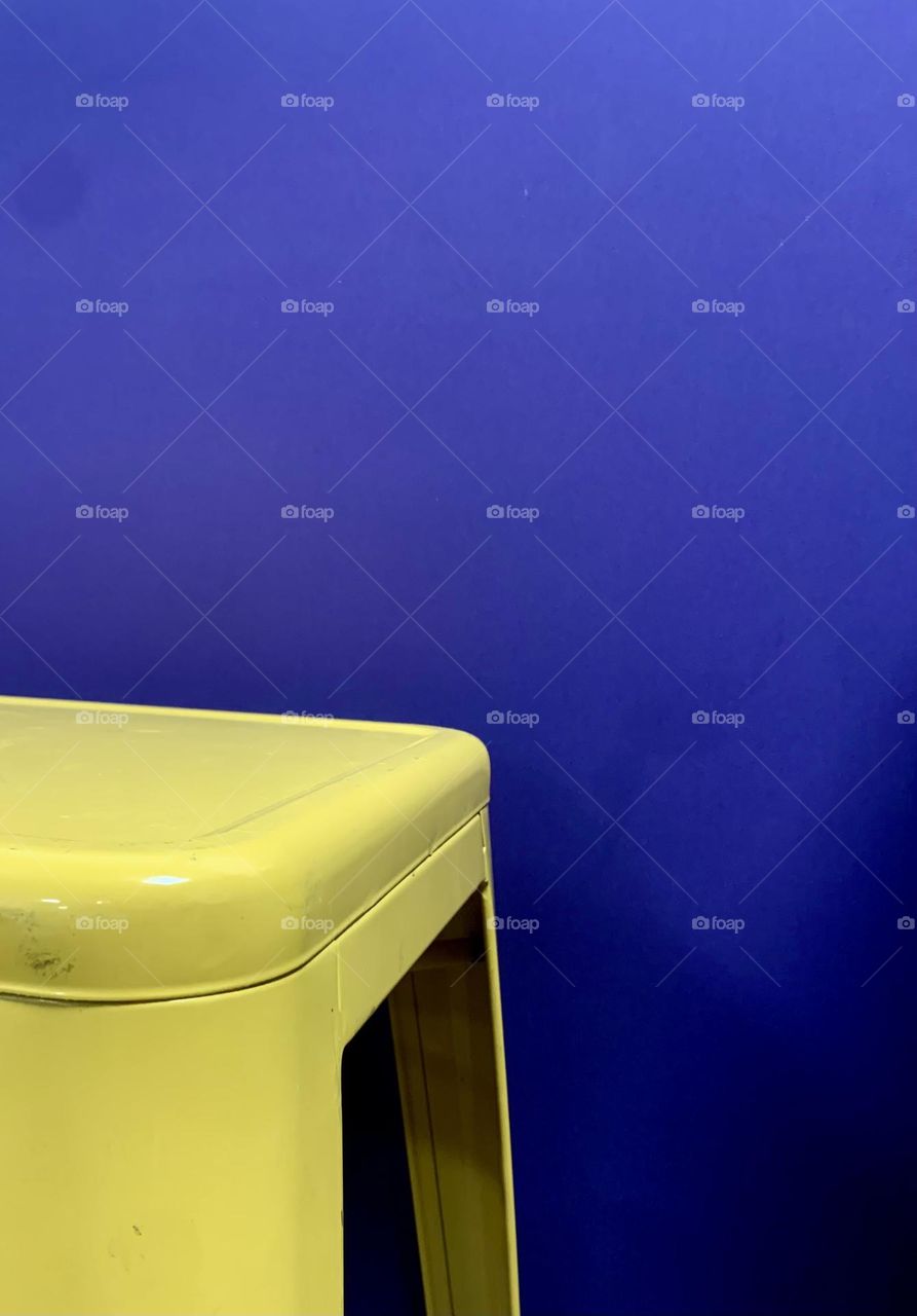 Yellow stool on purple background 