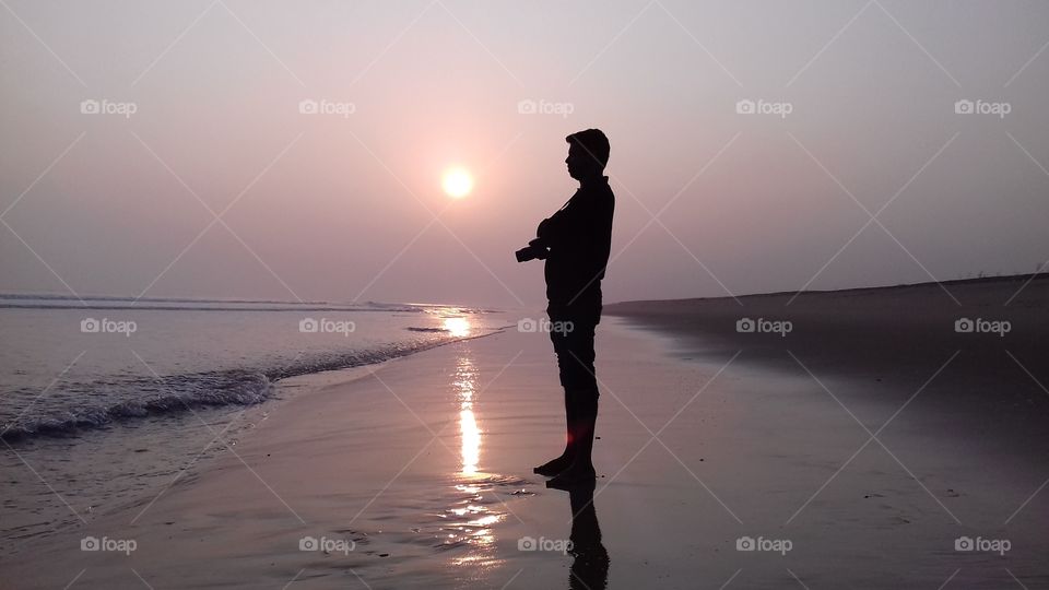 photographer enjoying sunset in sea Beach