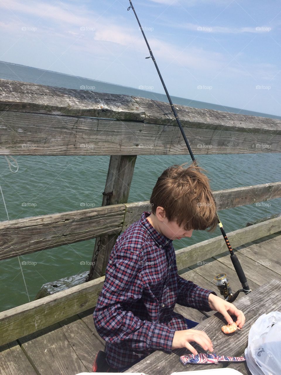 Boy fishing on pier 