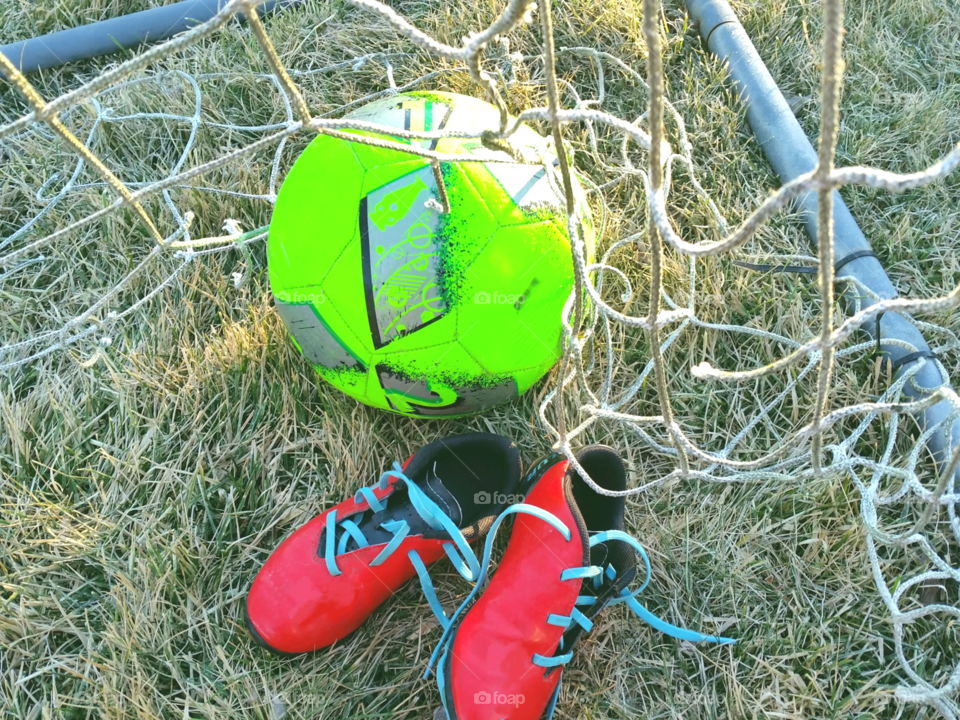 red soccer cleats with neon geen bal