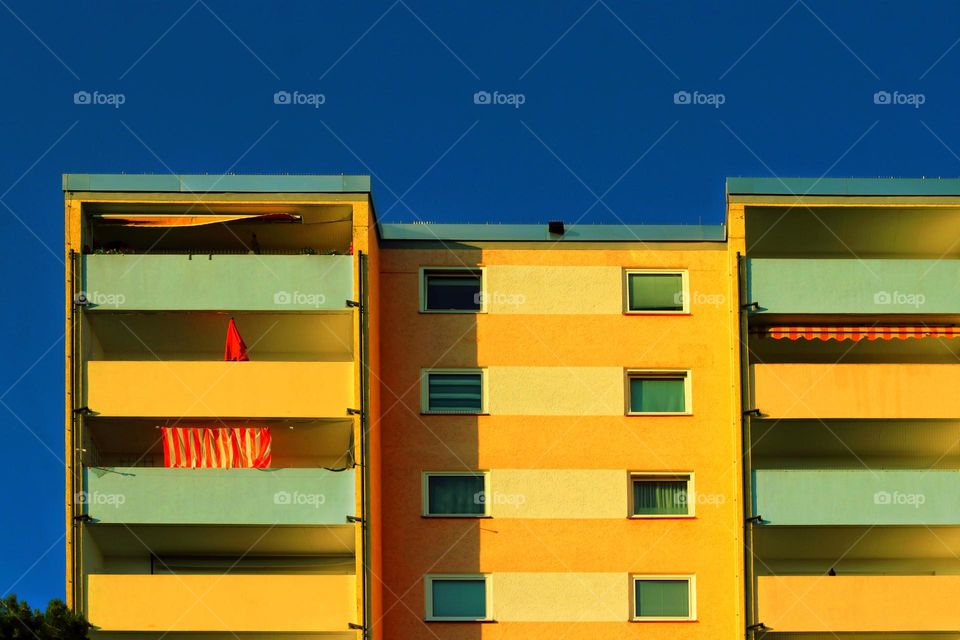 Colorful house with a parasol and awnings on a summer evening in a city 