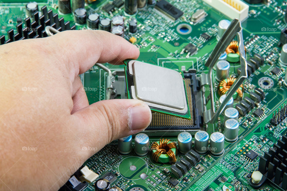 CPU in hand before installation into the motherboard