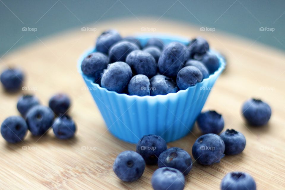 Fruits! - Blueberries In blue silicone baking cups on bamboo surface