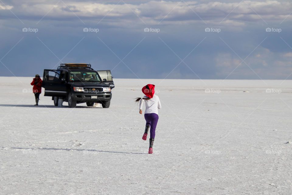 Girl is running on Salar de Uyuni