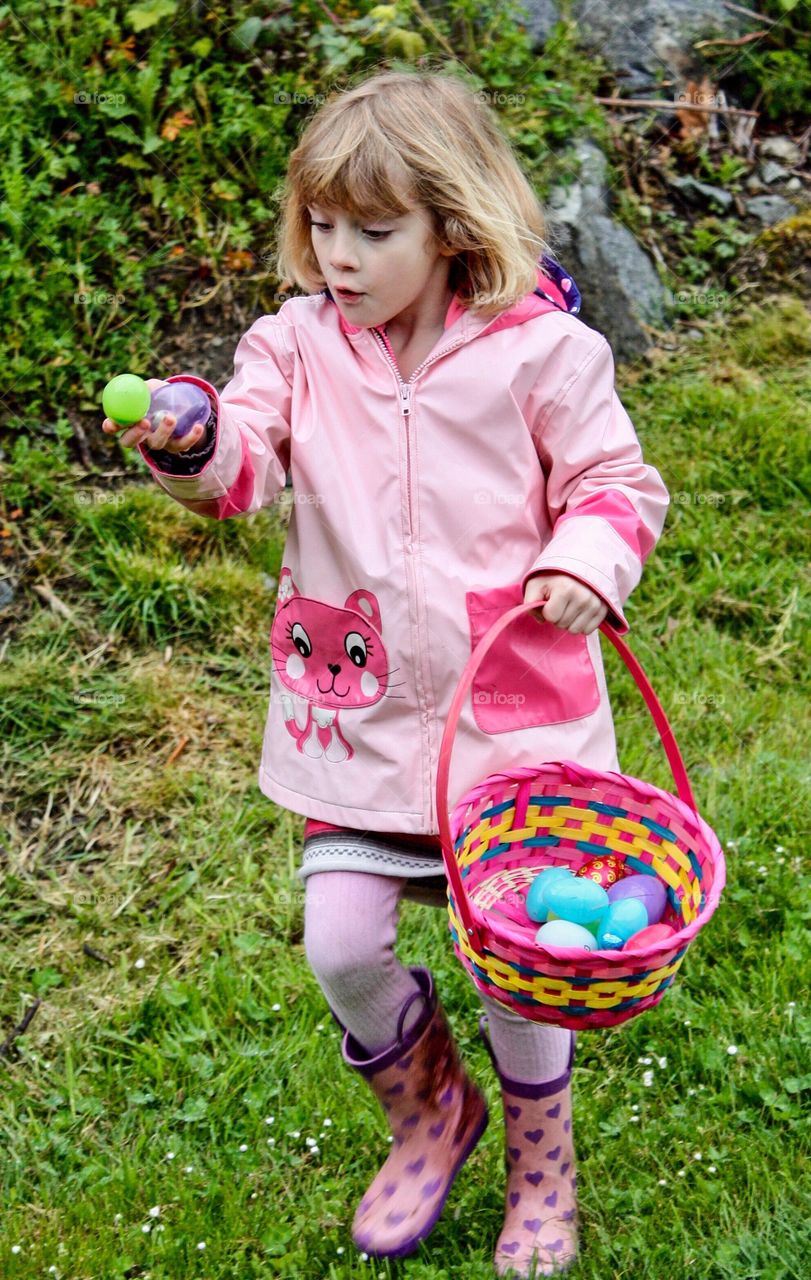 Young girl thrilled and surprised to find candy at Easter Egg Hunt