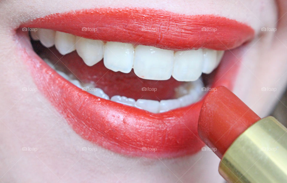 putting on red lipstick on lips