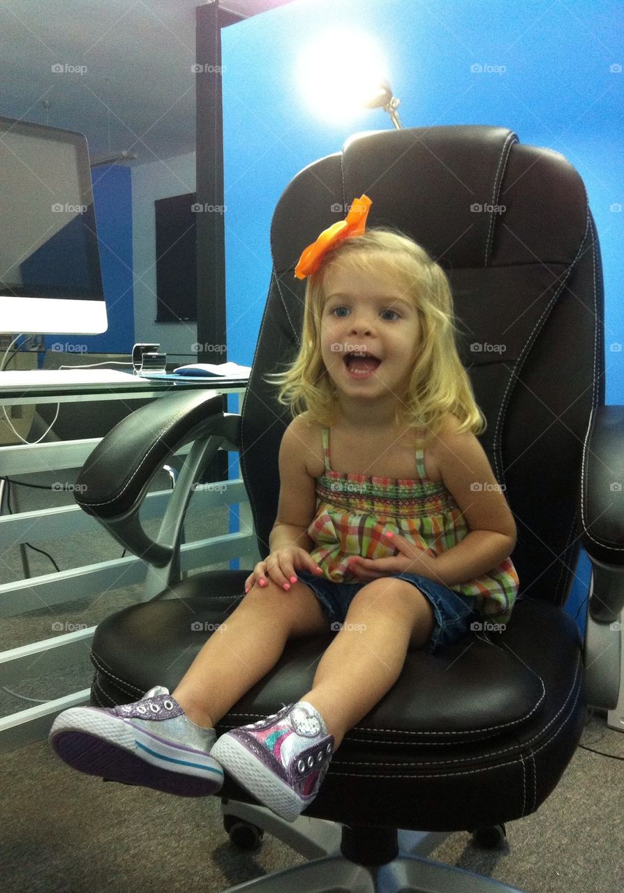 Happy little girl in dad's office