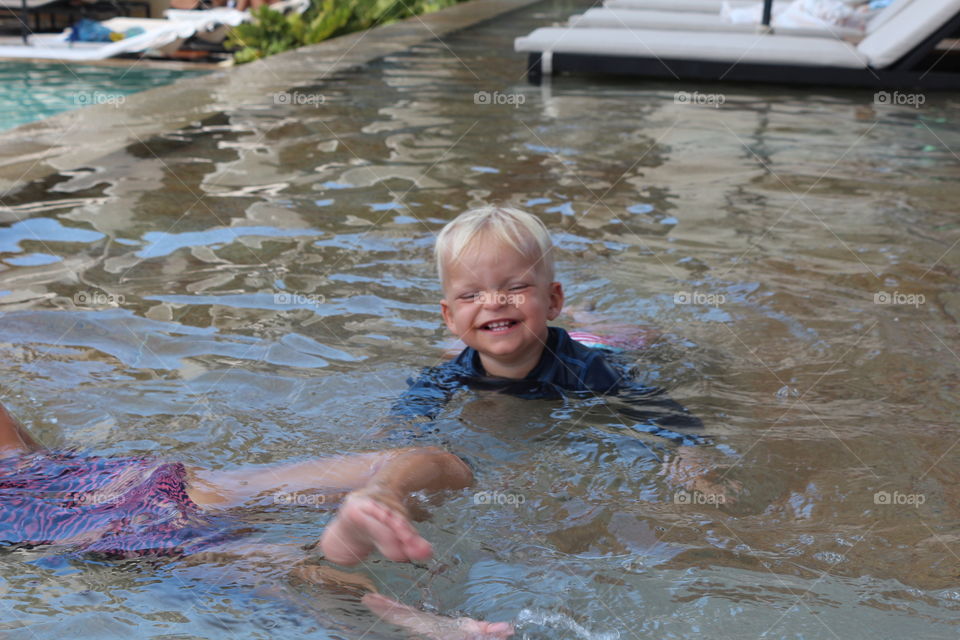 Cute baby boy having fun on a pool 
